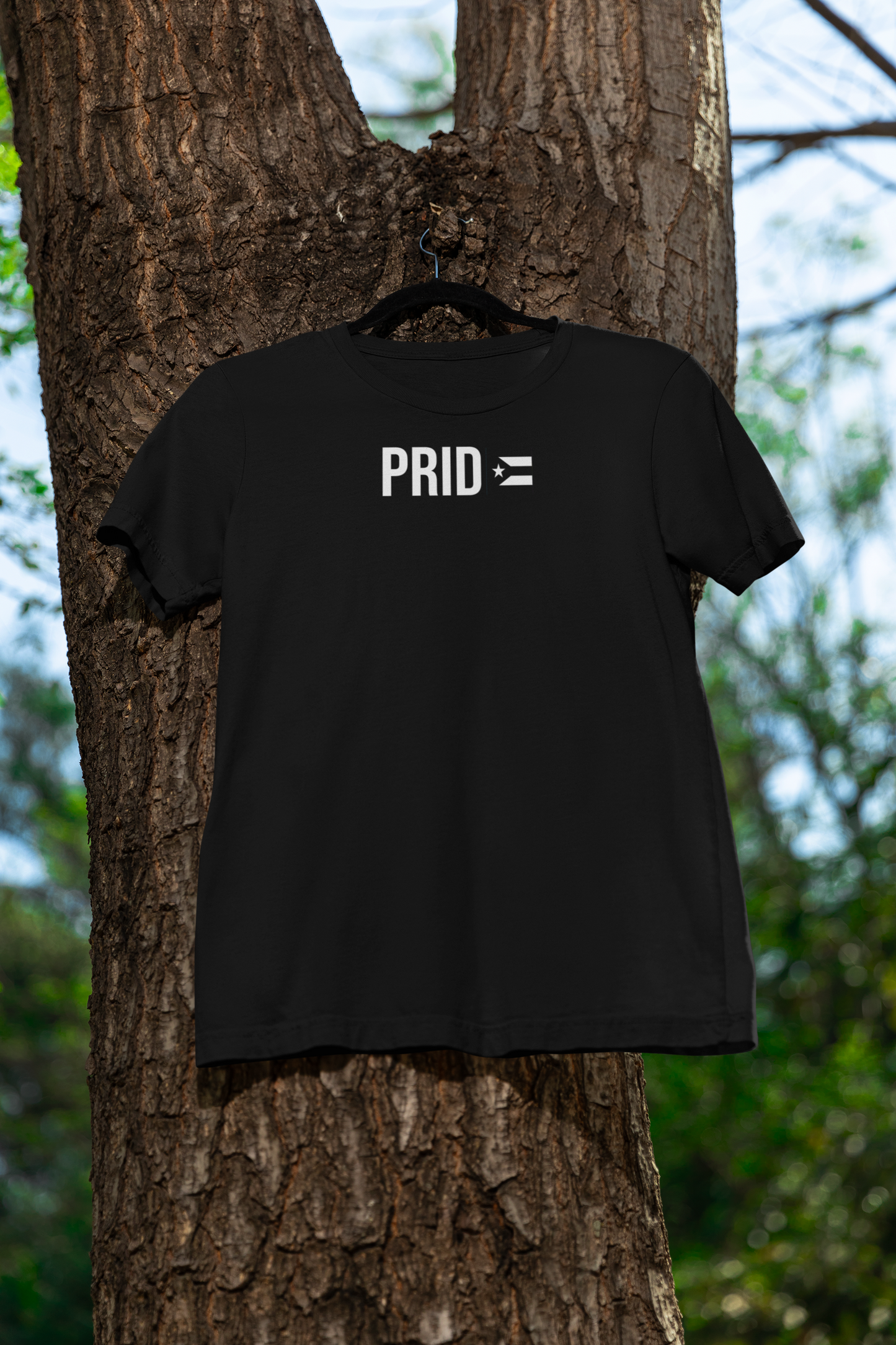 Black PRIDE Boricua La Resistencia tee with the Puerto Rican resistance flag (bandera negra) hanging on a tree — 100% cotton unisex LGBTQ+ Boricua pride shirt for the Puerto Rican diaspora.