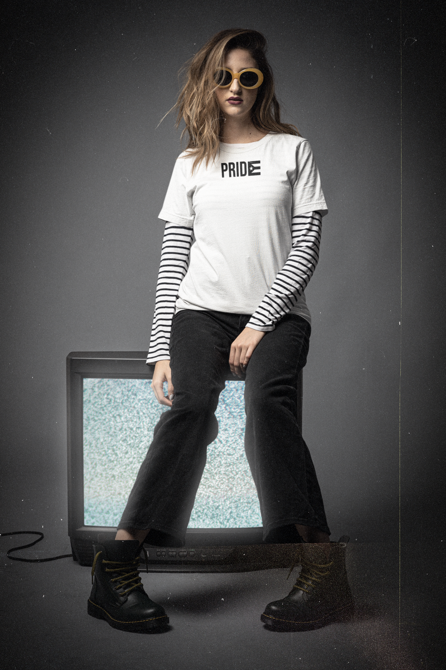 Editorial photo of a woman in a white PRIDE Boricua La Resistencia tee with the black Puerto Rican flag, retro 90s aesthetic — Boricua queer pride and resistance streetwear, designed in Puerto Rico.